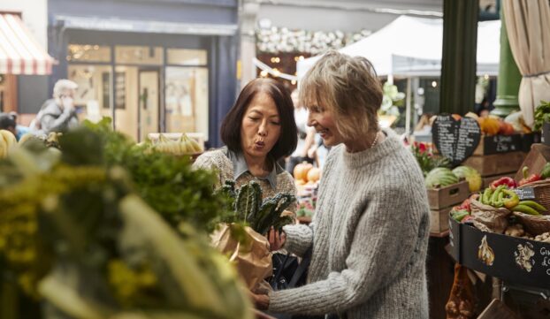 Deux femmes font les courses dans un marché.